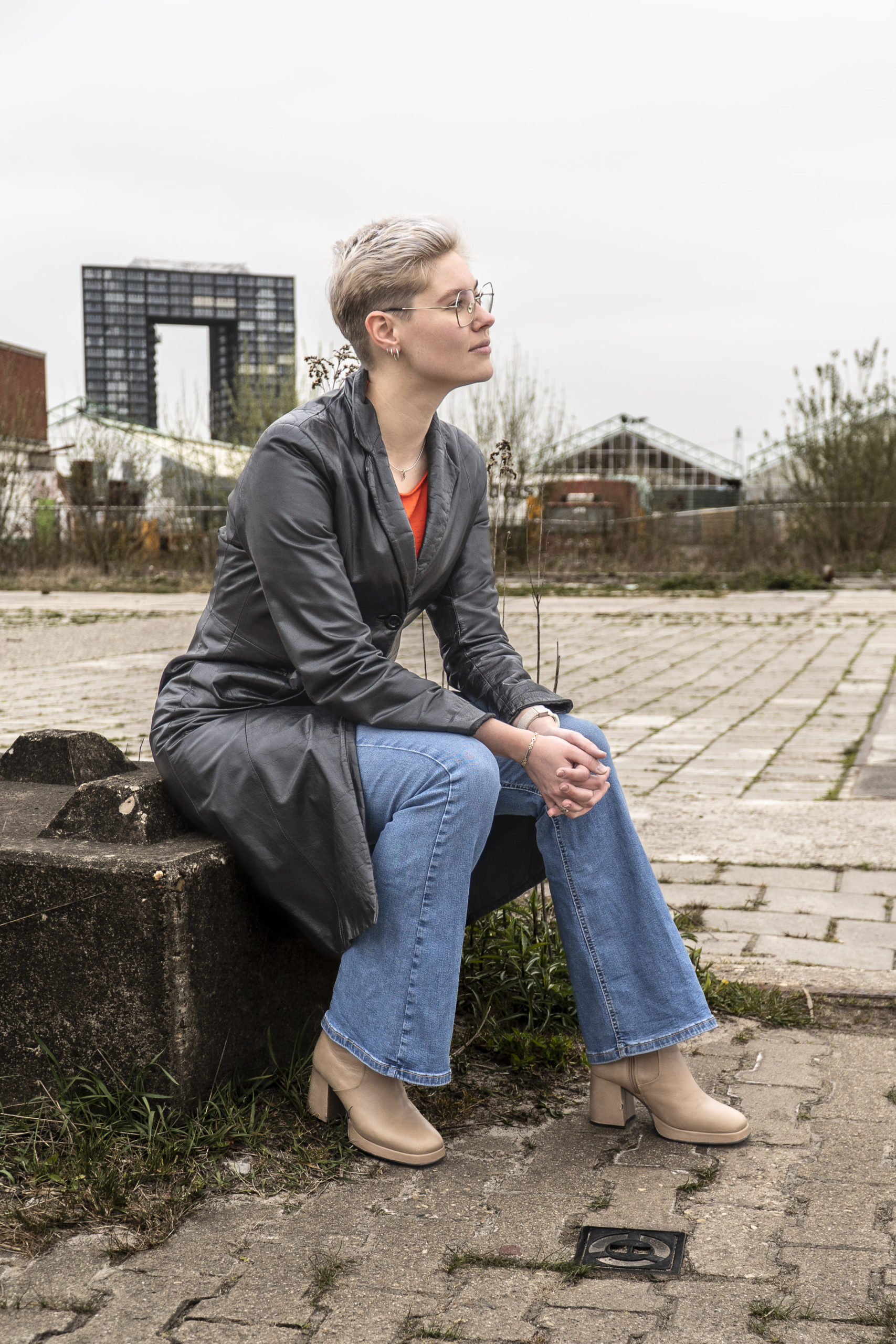 foto van vrouw met leren jas zittend op een steen